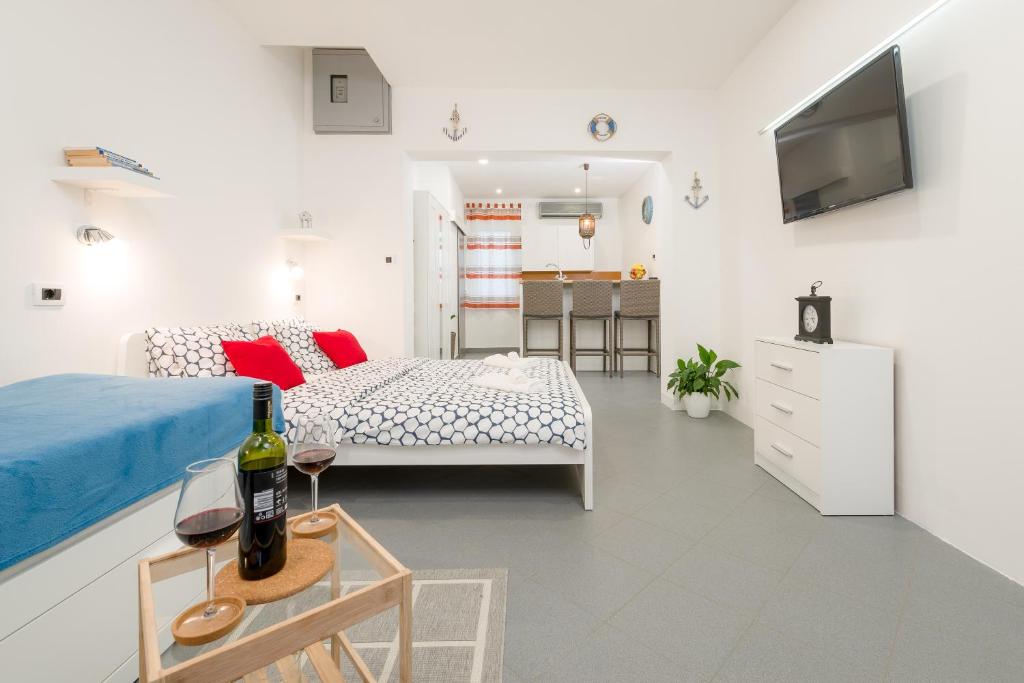 een slaapkamer met een bed en een tafel met een fles wijn bij Studio apartment Sesula in Split