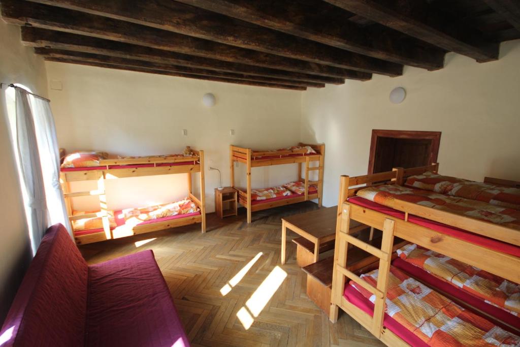 a room with three bunk beds and a couch at Hostel Skautský dom in Banská Štiavnica