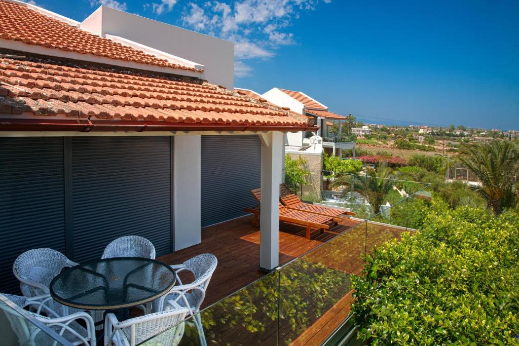 a balcony with a table and chairs on a house at Artemis Village Apartments & Studios in Stavros
