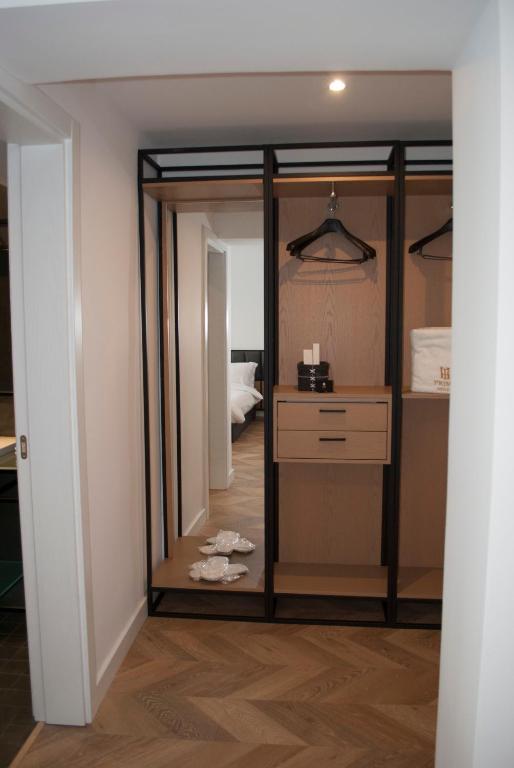a closet with glass doors and a dresser in a room at Prime Hotel in Tirana