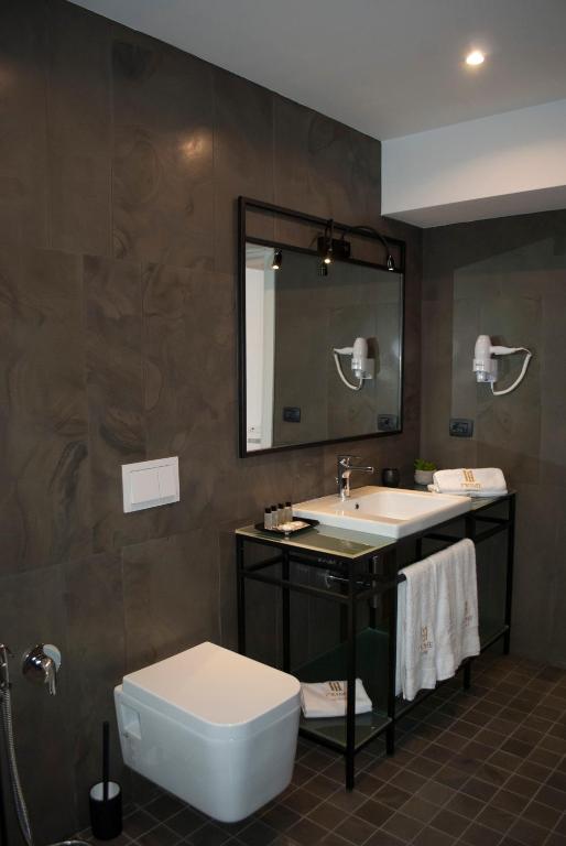 a bathroom with a sink and a toilet and a mirror at Prime Hotel in Tirana