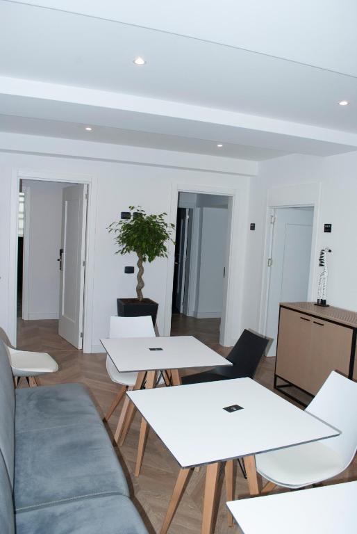 a room with white tables and a potted plant at Prime Hotel in Tirana