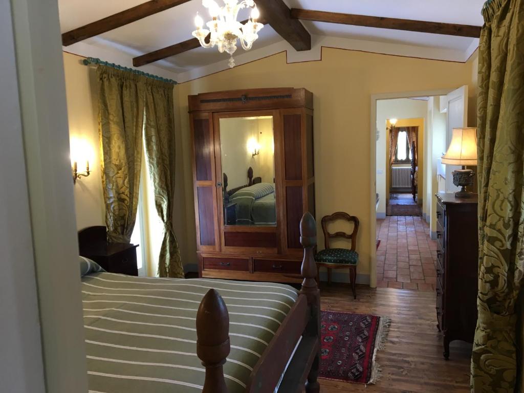カスティリオーン・フィオレンティーノにあるCasa Legnaiaのベッドルーム(ベッド1台、大きな鏡付)
