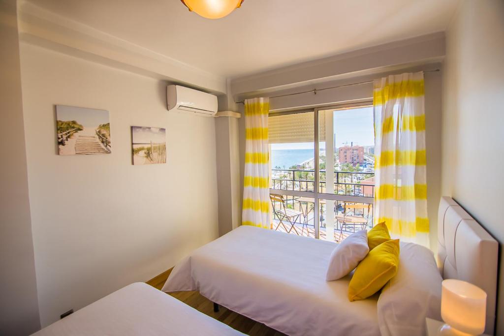 マラガにあるPiso primera línea de playaのベッドルーム1室(ベッド1台、景色を望む窓付)