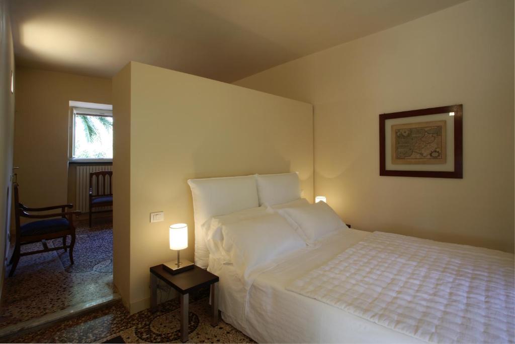 a bedroom with a bed and a lamp on a table at Villa Rosmarino in Camogli