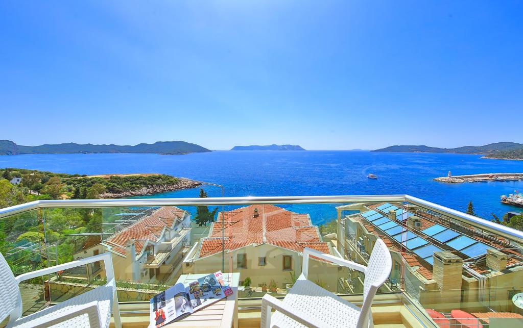 a balcony with chairs and a view of the water at Belinda Hotel in Kaş