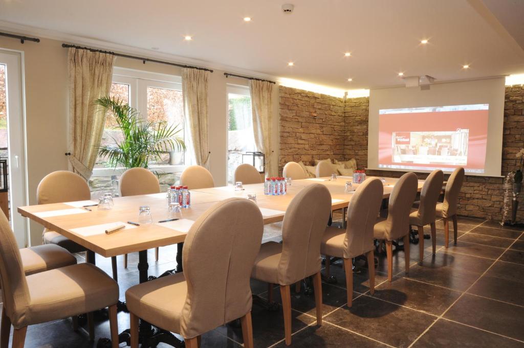 a conference room with a long table and chairs at Hotel Eifelland in Butgenbach