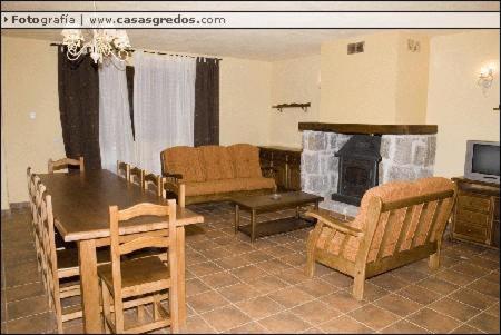 sala de estar con mesa y chimenea en Viv. De Uso Turístico Fuente el Tejo - Casa Ana, en Burgohondo