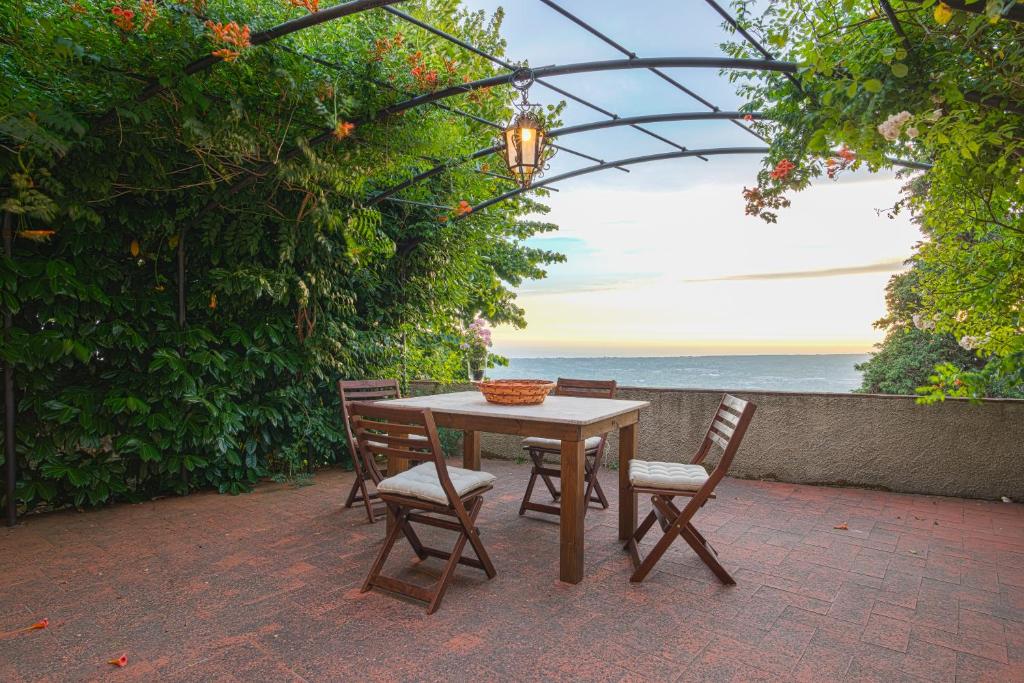a wooden table and chairs with a view of the ocean at Santa Lucia Suite Camaiore in Santa Lucia