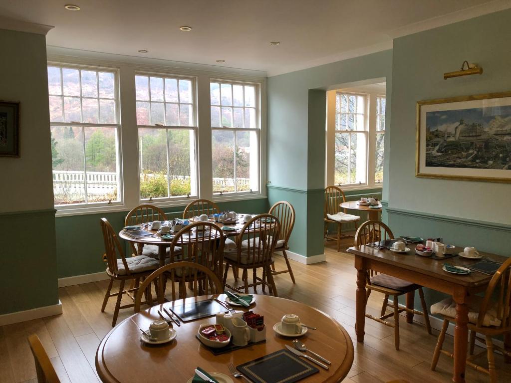 a dining room with tables and chairs and windows at Tigh na Cheo in Kinlochleven