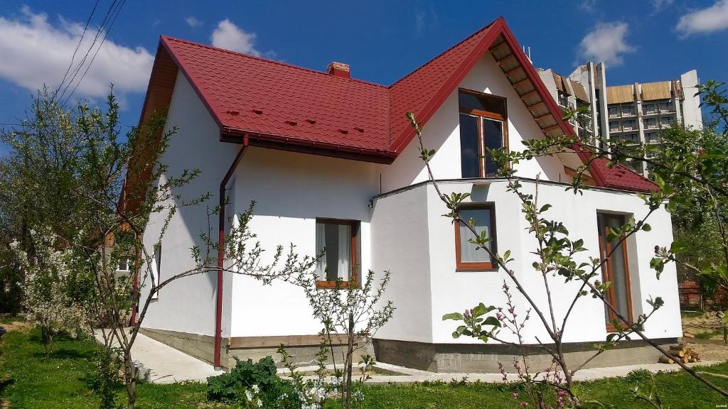 ein weißes Haus mit rotem Dach in der Unterkunft apartments BS in Truskawez