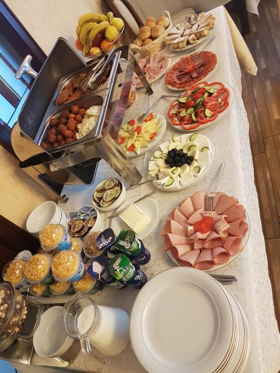 a table topped with plates of food on top at Pensiunea Genesa in Timişoara