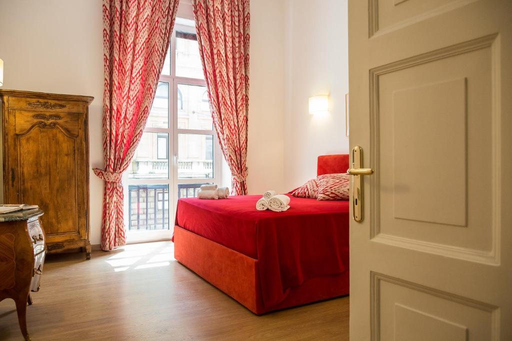 a bedroom with a red bed and a window at Prestigious Apartment via Barberini in Rome