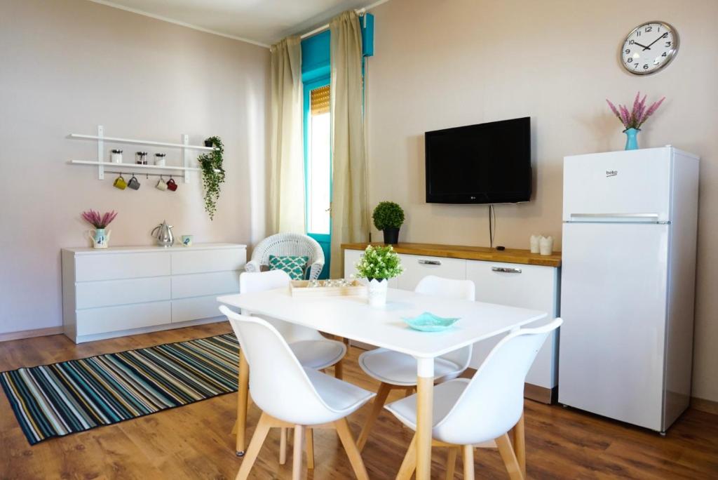 eine Küche und ein Esszimmer mit einem weißen Tisch und Stühlen in der Unterkunft Villa Aurelia -Seafront Apartment with Patio in Flumini di Quartu