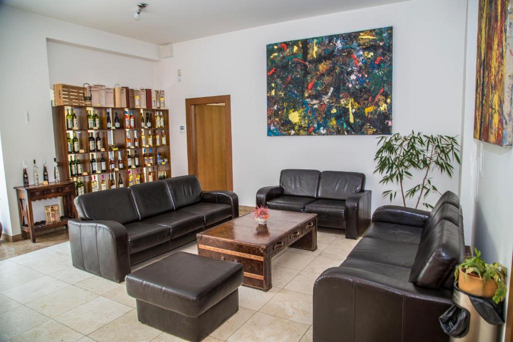 a living room with black leather furniture and a painting at Hotel Galant Lednice in Lednice