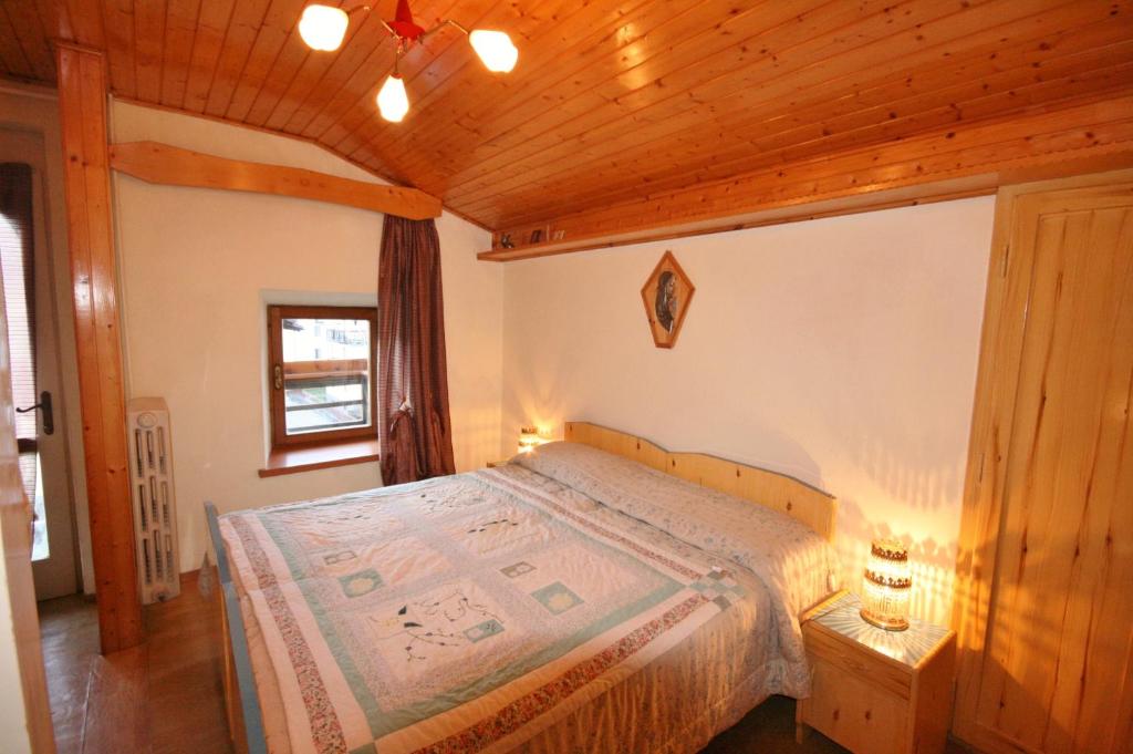 a bedroom with a bed with a wooden ceiling at Casa Katia in Canale dʼAgordo