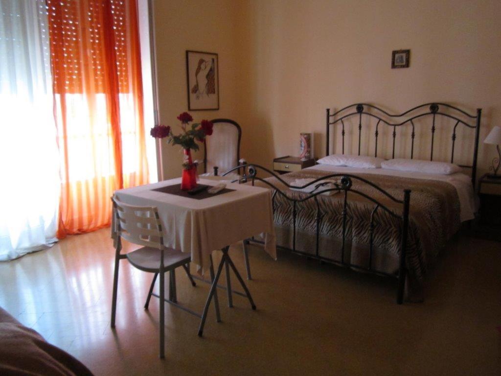 a bedroom with two beds and a table with flowers on it at Da Mary Guest House in Palermo