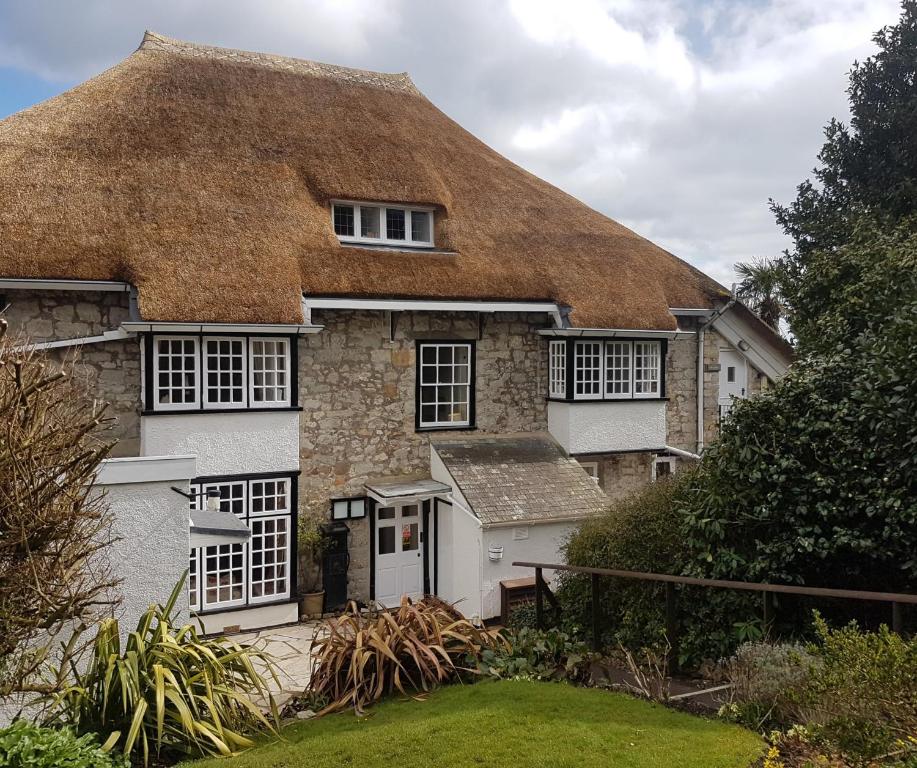 Cabaña con techo de paja y techo de hierba en Kersbrook Guest Accommodation, en Lyme Regis