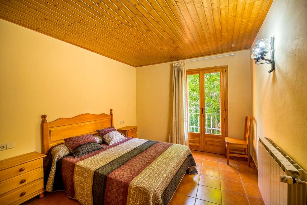 1 dormitorio con cama y ventana en Apartaments La Canal, en Alins