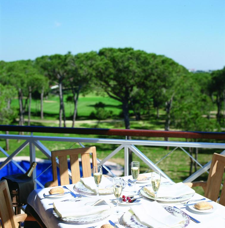 a table with plates and glasses on top of it at Hotel Nuevo Portil Golf in El Rompido
