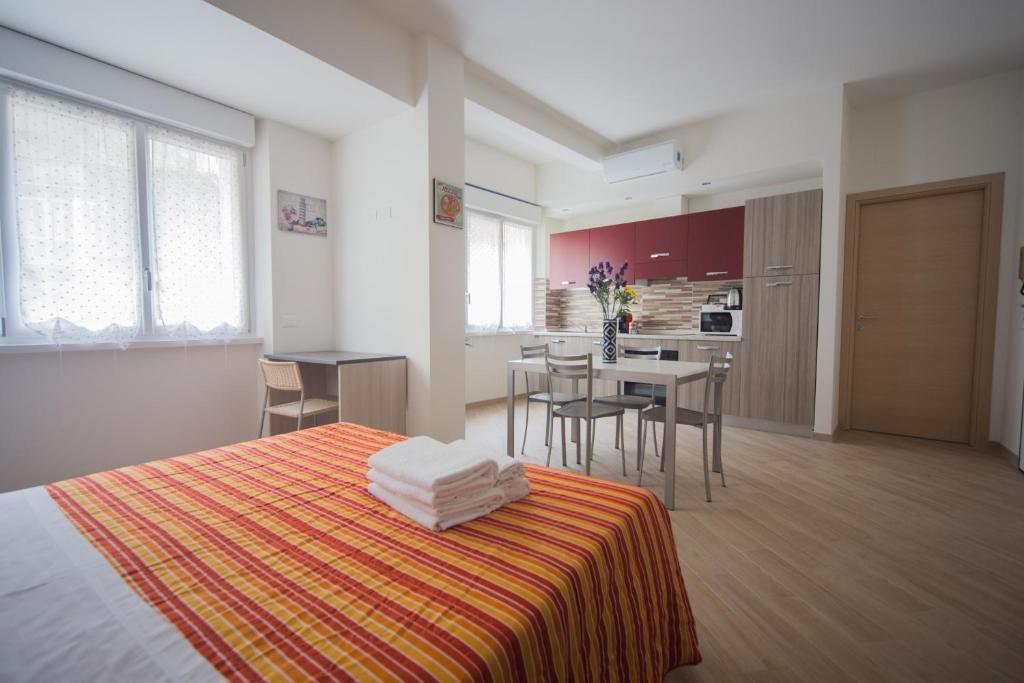 a bedroom with a bed and a kitchen with a table at Family Apartment London in Verona