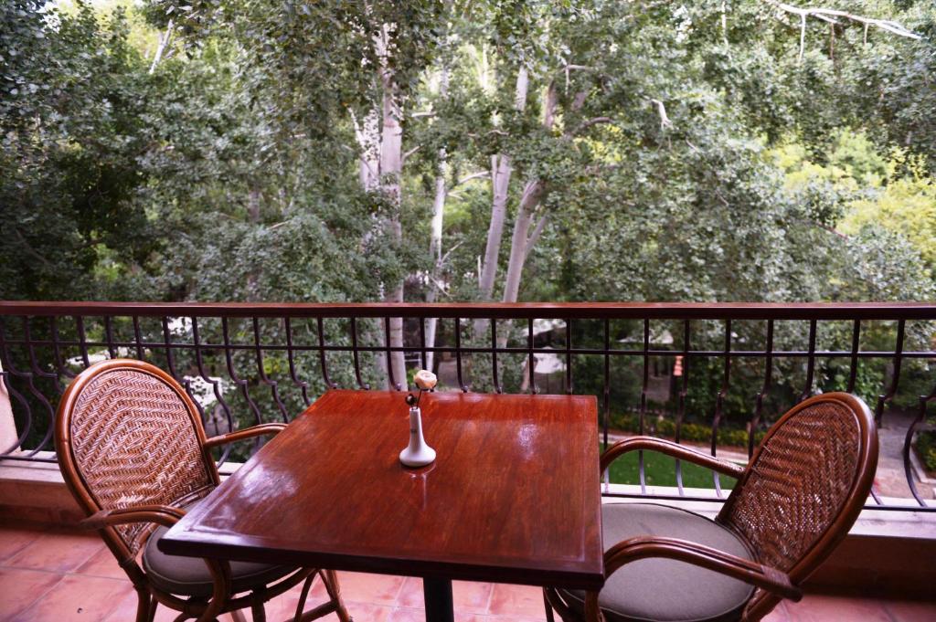 Chtaura的住宿－馬薩布基酒店，门廊上的木桌和椅子,享有美景