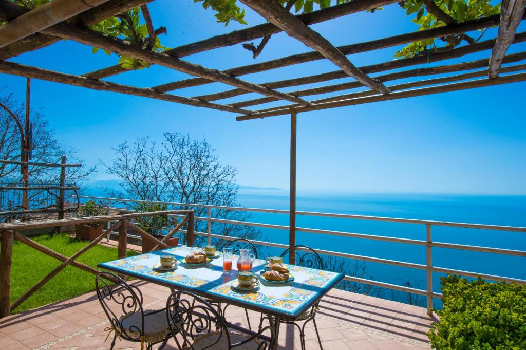 a table on a balcony with a view of the ocean at B&B Il Nespolo in Furore