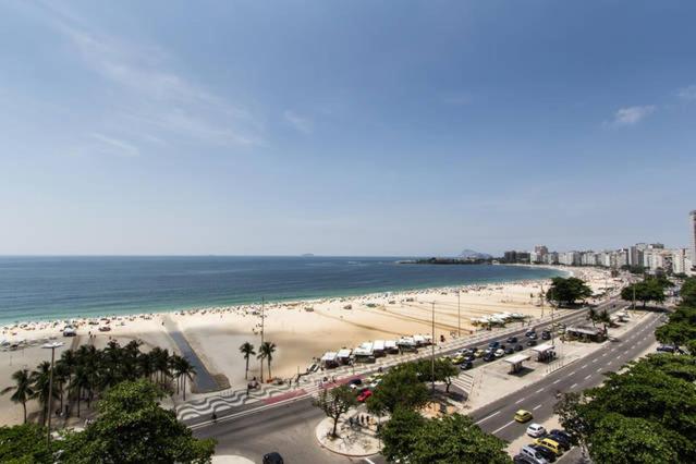 a view of a beach and the ocean with cars parked at Posto 4- Copacabana vista total mar 1003 in Rio de Janeiro