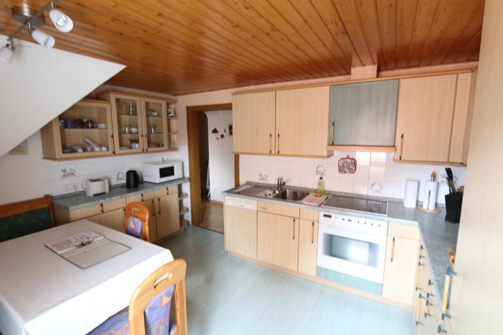 una cocina con armarios de madera y una mesa. en Gästewohnung in Algermissen, en Algermissen