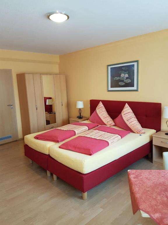 a bedroom with a large bed with pink pillows at Altstadt Hotel Peiß in Stralsund