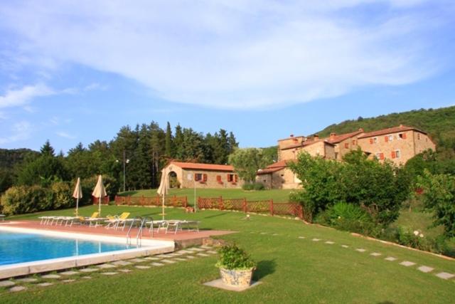 une grande cour avec une piscine en face d'une maison dans l'établissement Agriturismo Ca' Lucano, à Arezzo