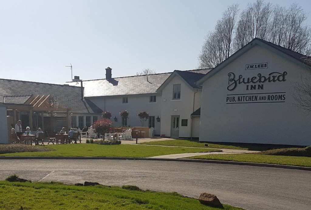 un bâtiment blanc avec un panneau sur son côté dans l'établissement The Bluebird Inn at Samlesbury, à Preston