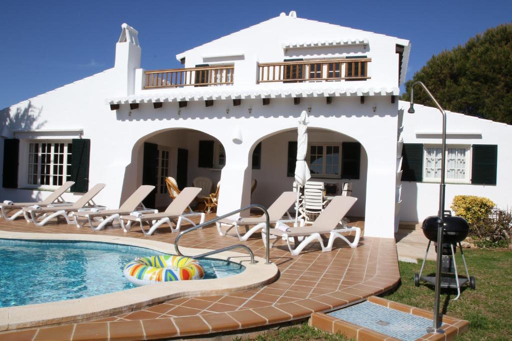 a villa with a swimming pool and a house at Villa Binigo in Binibeca