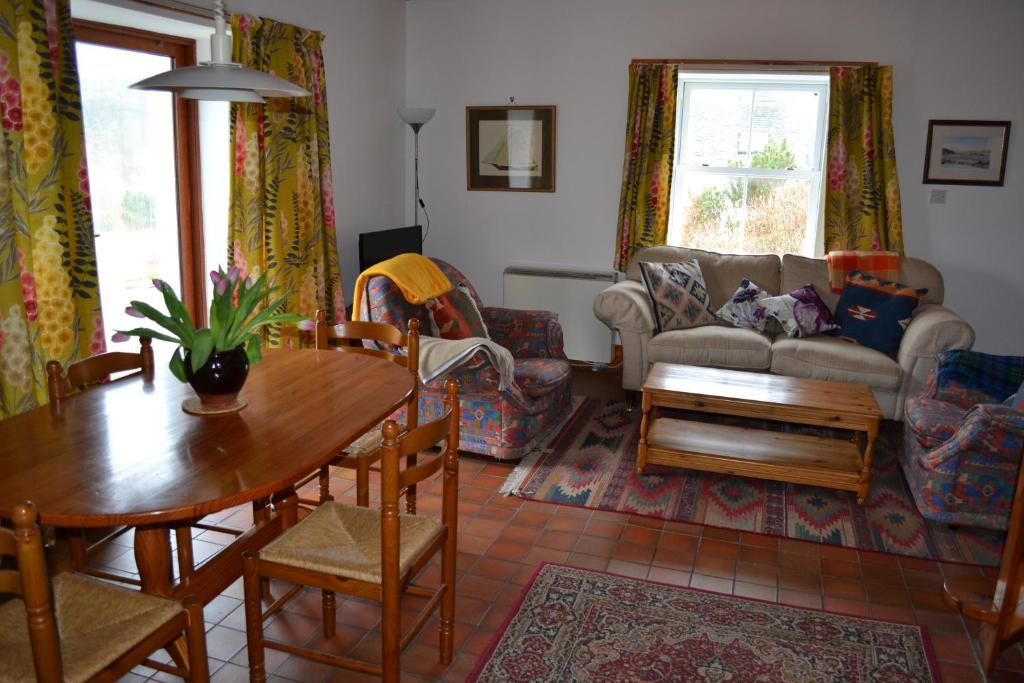 uma sala de estar com uma mesa e um sofá em Oban Seil Farm em Clachan