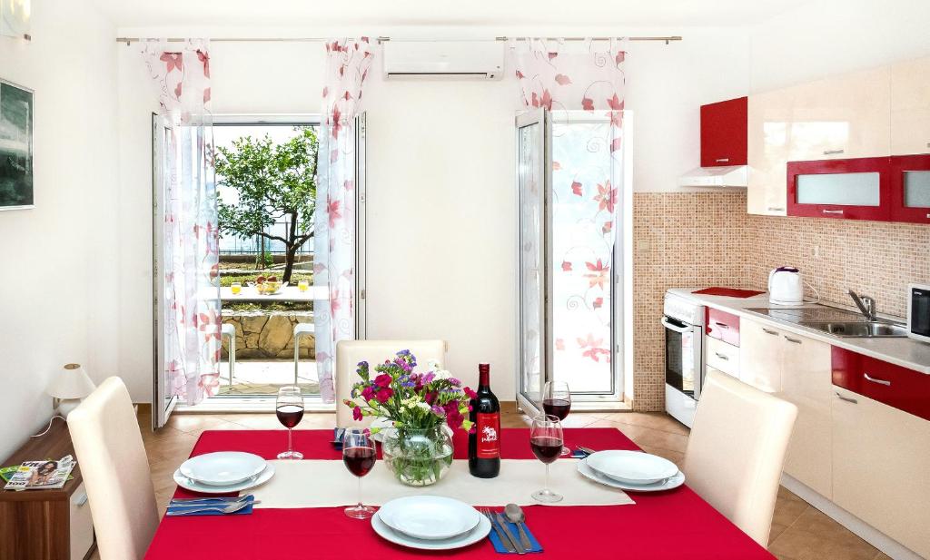 une cuisine avec une table et un chiffon rouge dans l'établissement Apartmani AMI, à Podstrana