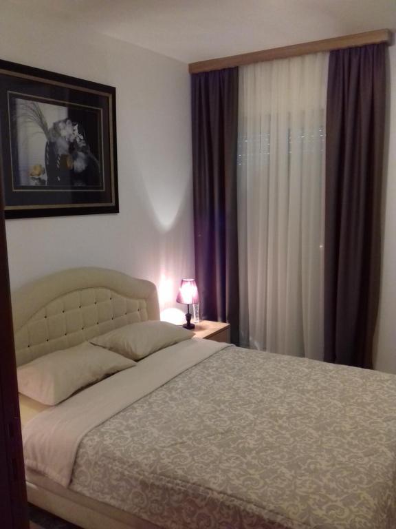 Schlafzimmer mit einem Bett und einem Fenster in der Unterkunft Aleksandra in Becici