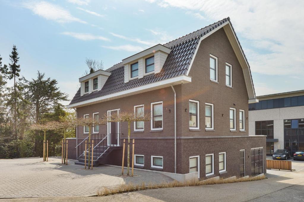 a large brick building with a gambrel roof at Luxury Family Residence Schinkeldijkje in Aalsmeer