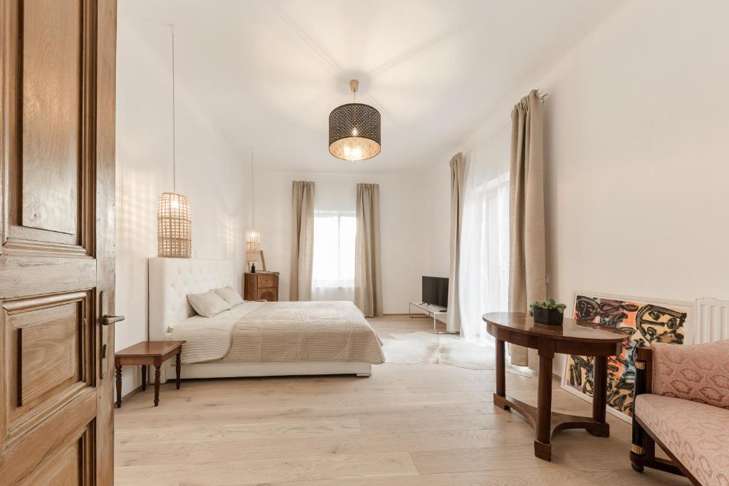 a white bedroom with a bed and a couch at Schloss Pesenbach Chalet im Freizeitland Feldkirchen an der Donau in Feldkirchen an der Donau