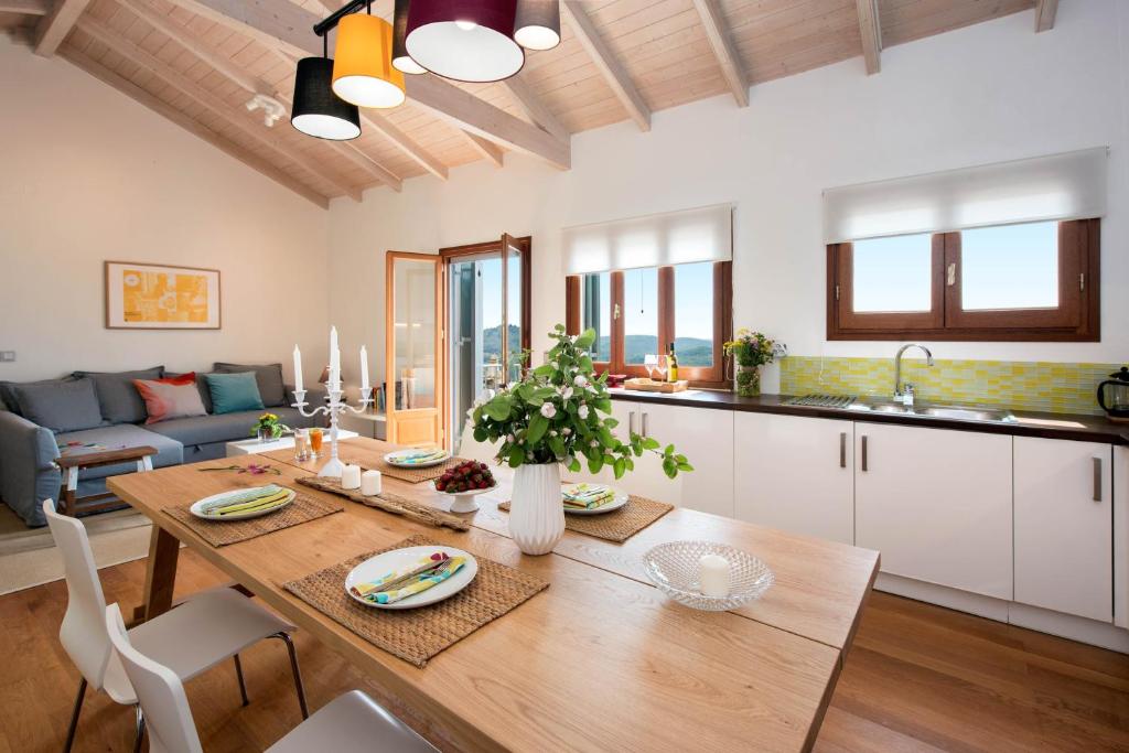 a kitchen and living room with a wooden dining table at Lavender Cottage. in Skriperón