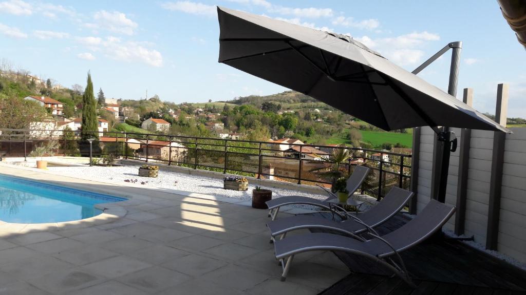 - une terrasse avec une chaise et un parasol à côté de la piscine dans l'établissement chambre chez mamie do, à Vertaizon