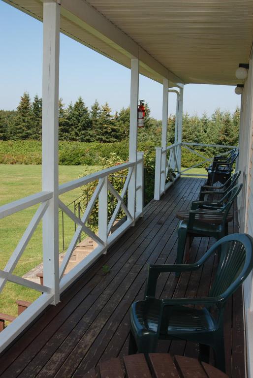 a porch with chairs sitting on top of it at Shining Waters - Ingleside Cottages in Cavendish