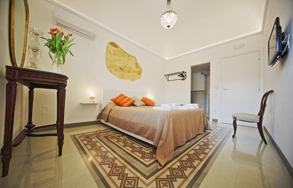パレルモにあるPalazzo Torre Apartmentのベッドルーム1室(ベッド1台、テーブル、椅子付)