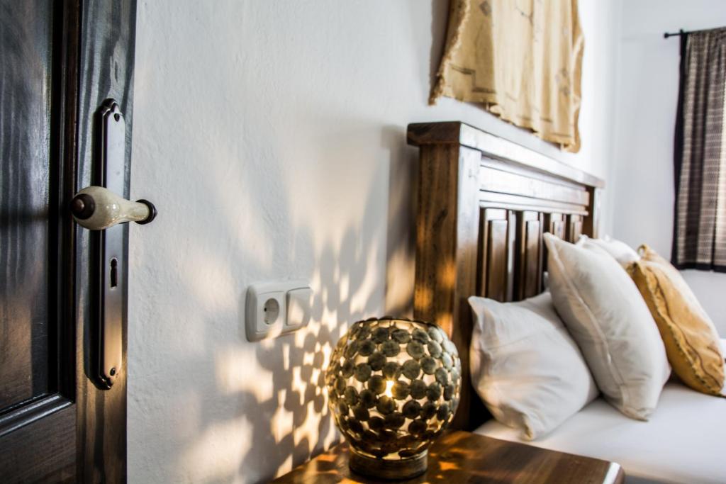 1 cama con almohadas blancas y un jarrón sobre una mesa en Casa Tahiche - Jacuzzi, WIFI & BBQ, en Tahiche