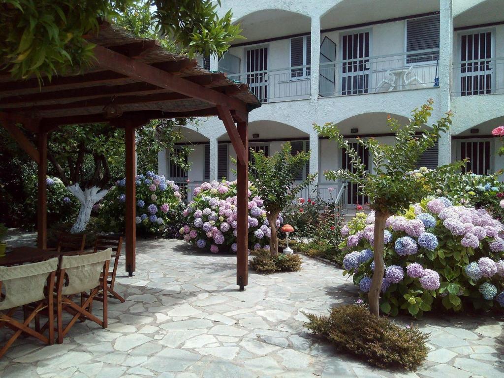 un jardín con flores rosas y moradas frente a un edificio en Margarita Apartments, en Preveza