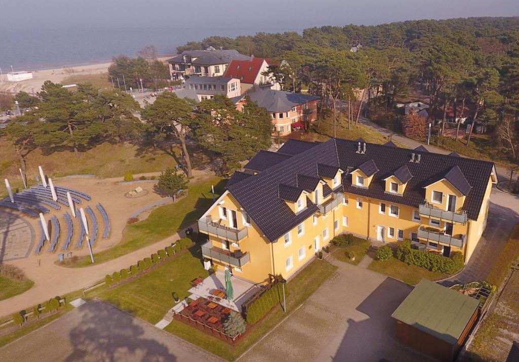 uma vista superior de uma grande casa amarela com um quintal em Ferienwohnung zur Düne em Trassenheide