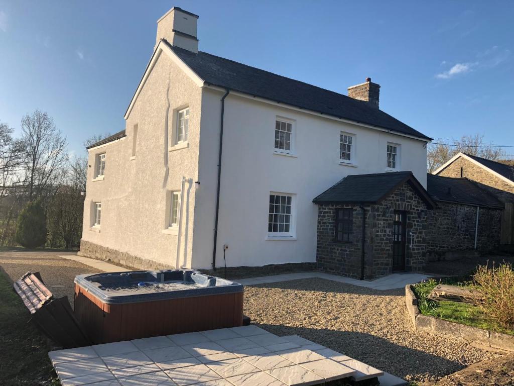 a large white house with a bath tub in front of it at Pengarreg Fawr in Llanilar