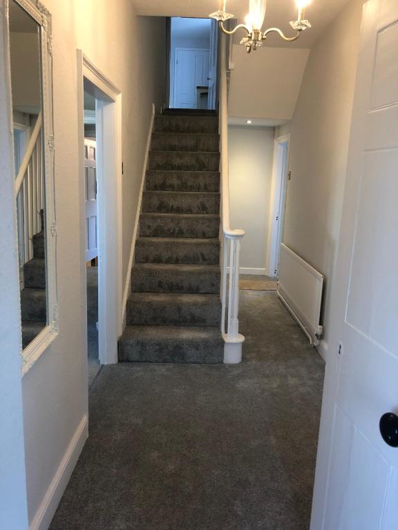 a hallway with stairs in a home with a chandelier at Pengarreg Fawr in Llanilar