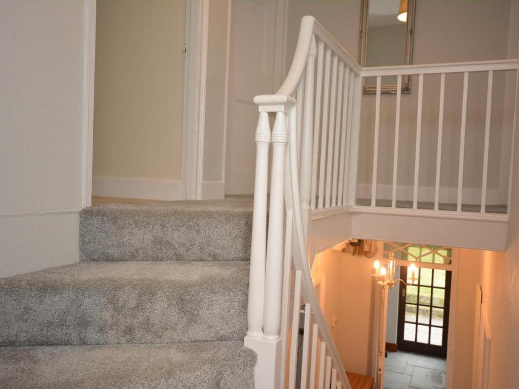 a staircase in a home with white railings at Pengarreg Fawr in Llanilar