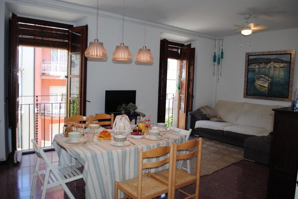 a living room with a table with chairs and a couch at Casa 1627 in Blanes