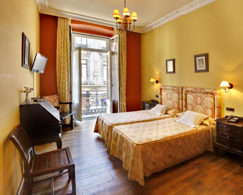 um quarto com uma cama, um piano e uma janela em Hotel Villa de Luarca em Luarca